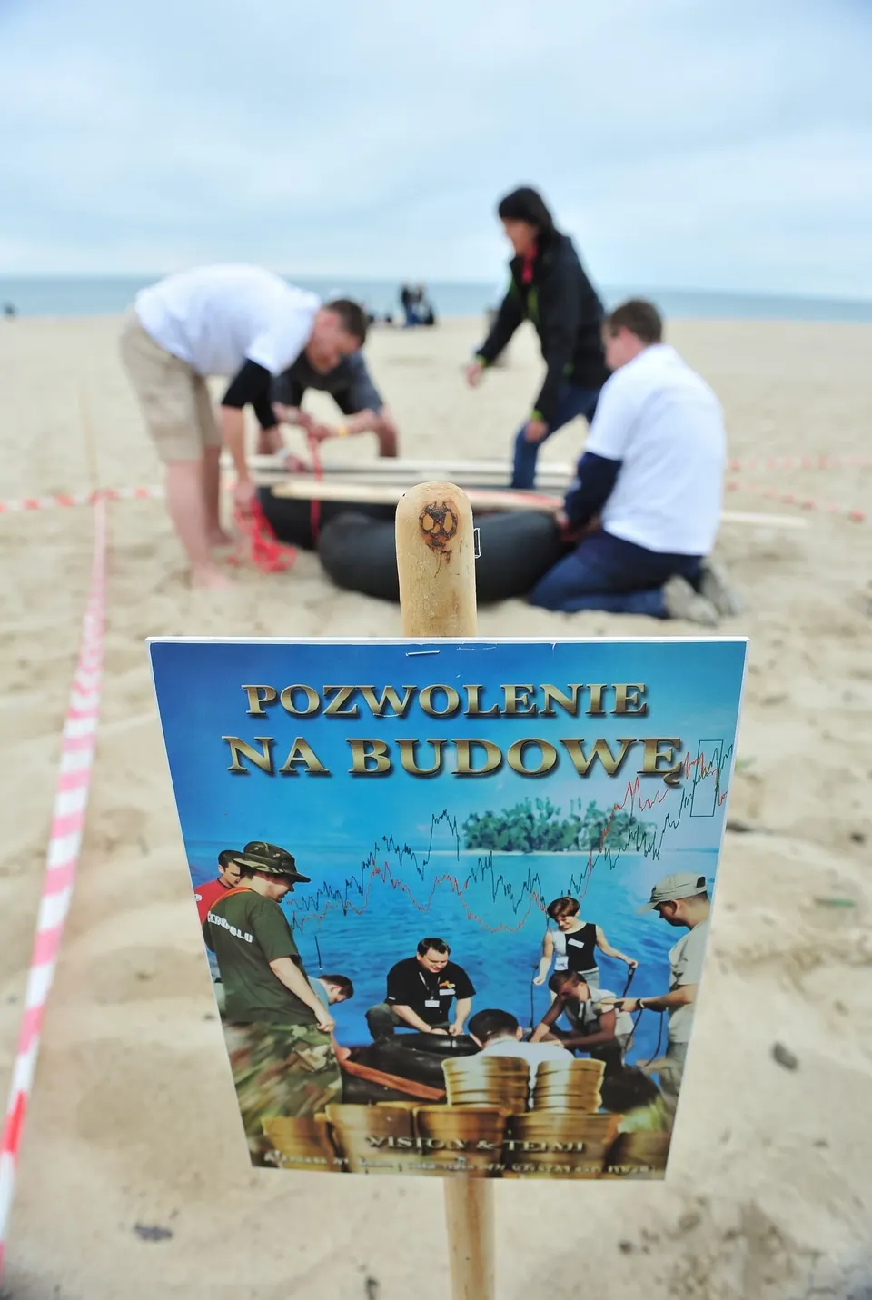 Tabliczka z napisem pozwolenie na budowę przed drużyną budującą tratwę