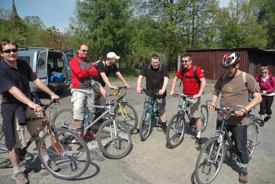Grupa rowerzystów z rowerami górskimi na parkingu przed startem trasy