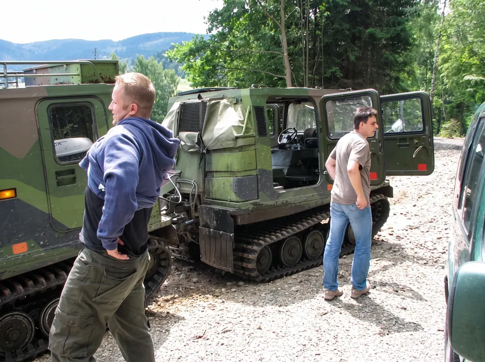 Uczestnicy przy gąsienicowym pojeździe terenowym na żwirowej drodze