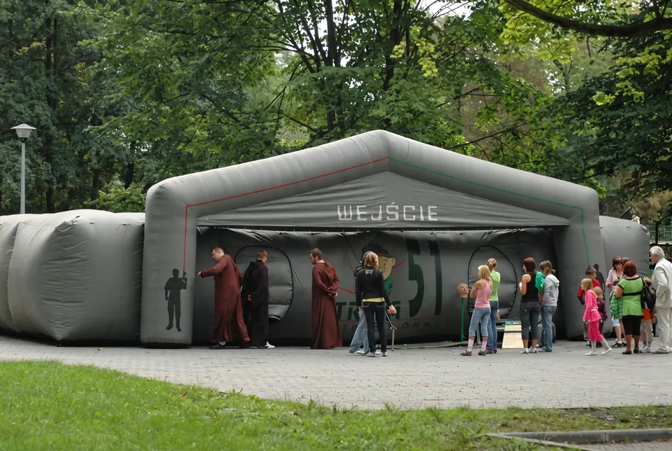 Dmuchana hala areny laserowej z wejściem i czekającymi uczestnikami w parku